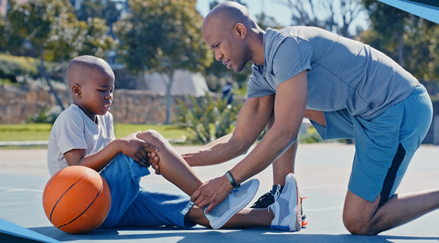 A dad helping his son with an injury on a basketball court